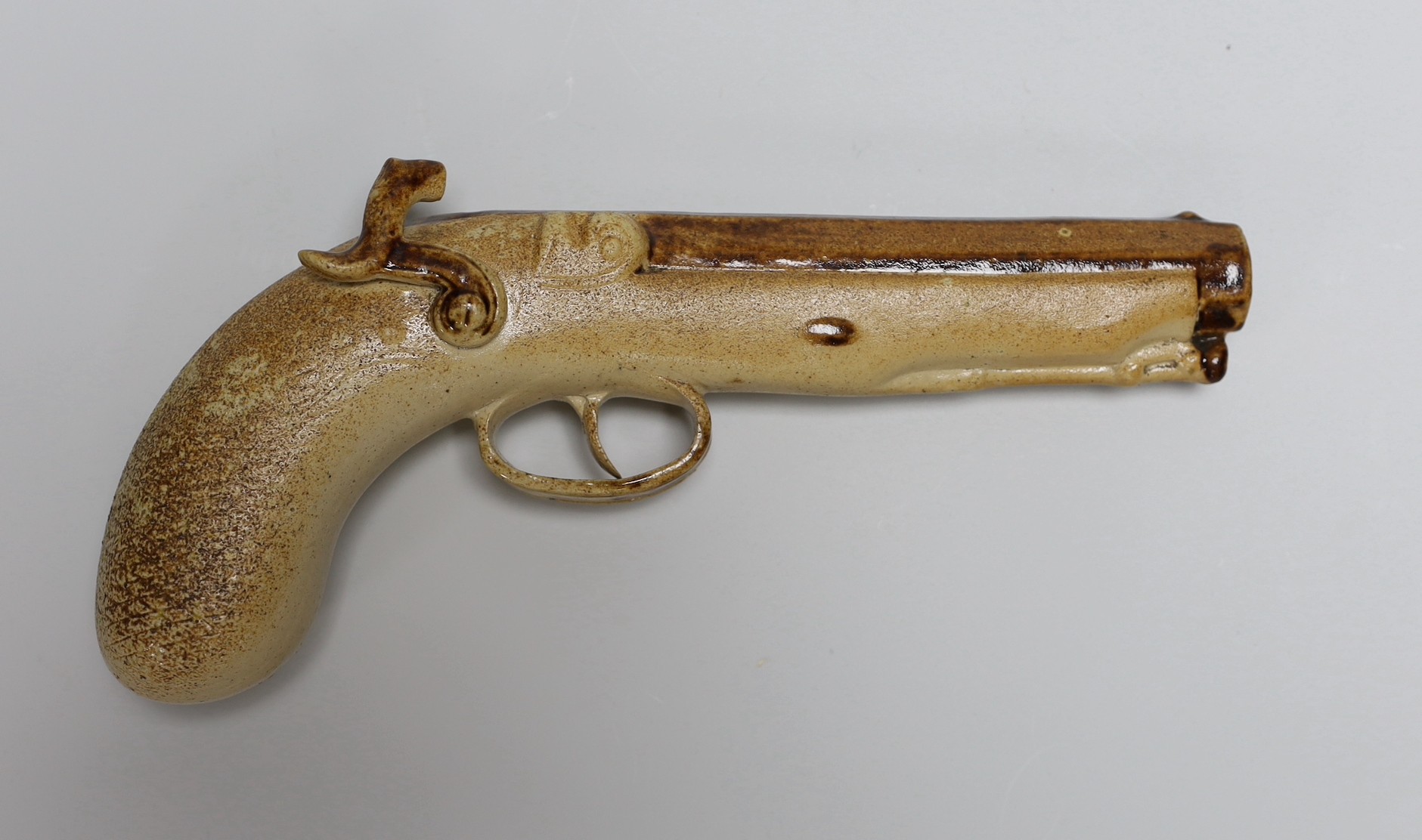 Two Georgian slip-cast Prattware figures and a Victorian salt glazed stoneware novelty pistol liquor flask, 24cm (3)